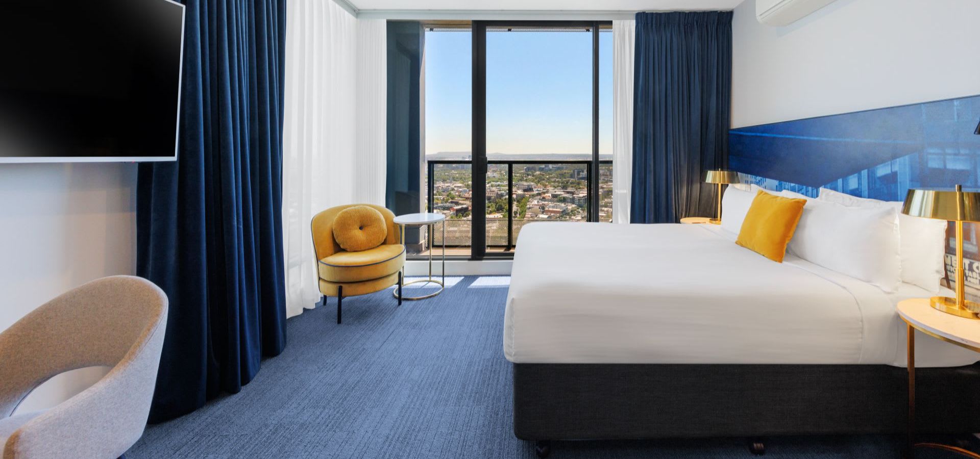 The Executive Studio room at Avani Melbourne Jazz Corner Residences with a large bed and city views