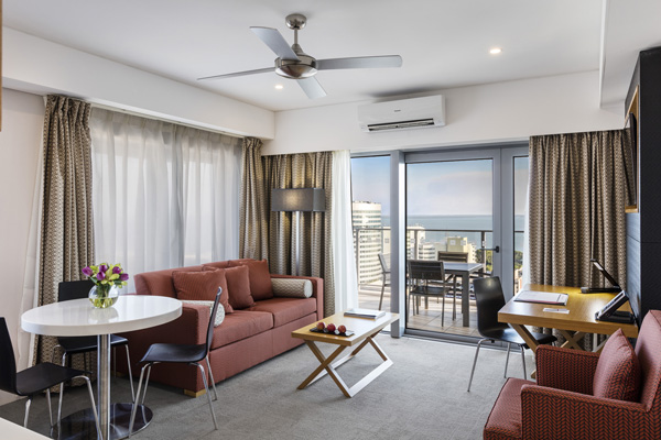 spacious family friendly living room area in 1 bedroom hotel in Darwin with air con and balcony