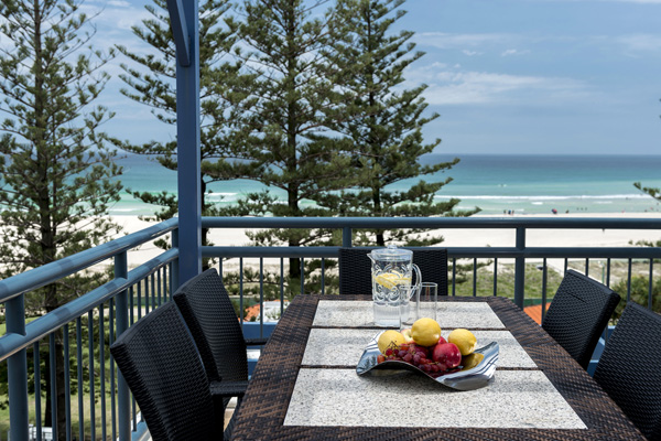 balcony of two bedroom apartment with table and chairs and views of beach and ocean in Coolangatta, Gold Coast, Australia